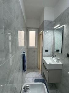 a bathroom with a sink and a toilet and a mirror at La Casa Di Nonno Roberto in Livorno