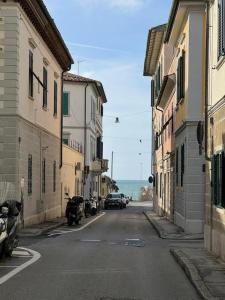 an empty street with cars parked on the side of the road at La Casa Di Nonno Roberto in Livorno