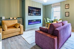 uma sala de estar com duas cadeiras e uma televisão em Silcox House Bath em Bath
