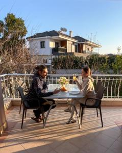 two women sitting at a table on a patio at A COZY HOME for A LARGE FAMİLY in Marmaris