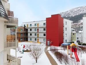 a red building with a playground in the snow at Bergen's Finest: Sleek Oasis with Two Bedroom in Bergen