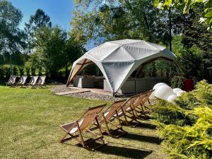 チェンストホヴァにあるHotel Archeの庭の一組の椅子とテント
