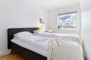 2 łóżka w białej sypialni z oknem w obiekcie Bergen's Finest: Sleek Oasis with Two Bedroom w Bergen