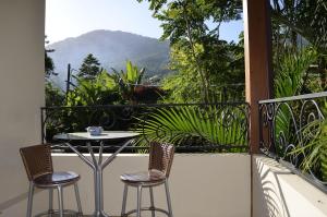 イリャベラにあるSuítes Paquetá Ilhabelaのテーブルと椅子2脚、景色を望むバルコニー