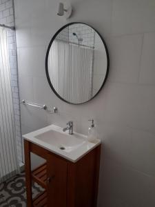 a bathroom with a sink and a mirror on the wall at Arenales 1 in Azul