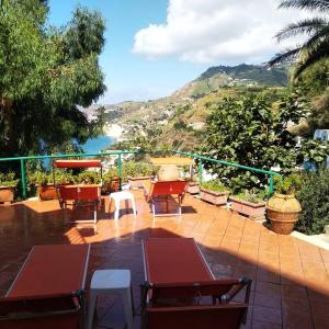 eine Terrasse mit Tischen und Stühlen und Meerblick in der Unterkunft Hotel Villa al Mare in Ischia