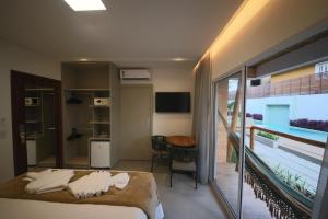 a hotel room with a bed and a balcony at Uri Pousada in Maragogi