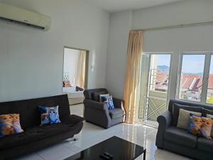 ein Wohnzimmer mit 2 Sofas und einem großen Fenster in der Unterkunft Homestay Pangsapuri Simfoni 3BR 7Pax Kuah Langkawi in Kuah