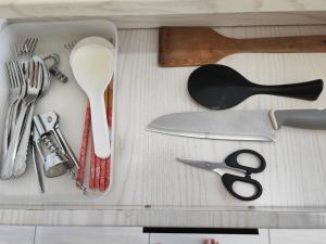 uma gaveta cheia de utensílios de cozinha numa mesa em Homestay Pangsapuri Simfoni 3BR 7Pax Kuah Langkawi em Kuah