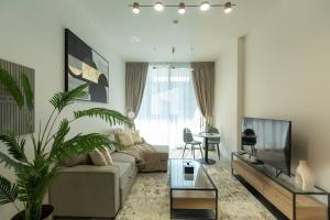 a living room with a couch and a tv at Amazing Pool View In 1br Apt - Jvc Dubai in Dubai