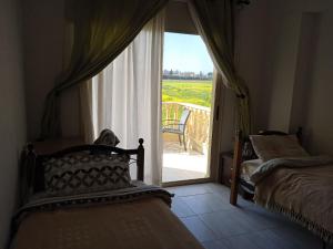 a bedroom with two beds and a window with a view at ZenBerry house in Mandria