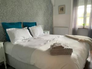 1 dormitorio con 1 cama blanca grande y toallas. en Welcoming and peaceful bed and breakfast, en Fougerolles-du-Plessis