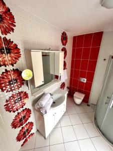 a bathroom with a white sink and a red wall at A COZY HOME for A LARGE FAMİLY in Marmaris