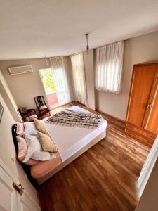 a bedroom with a large bed and a wooden floor at A COZY HOME for A LARGE FAMİLY in Marmaris