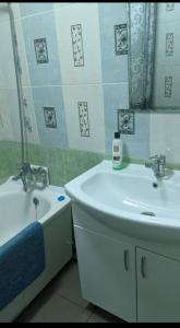 ein Badezimmer mit einem Waschbecken, einer Badewanne und einem Spiegel in der Unterkunft Relax House Downtown !!! in Bălţi