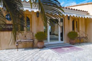 un bâtiment avec un banc devant une porte dans l'établissement Hotel la Caravelle, à Bonifacio