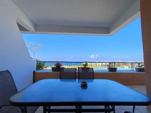 una mesa azul en un balcón con vistas al océano en Kings Palace - spacious 2-bed with sea views and large patio, en Pafos