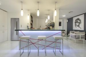 a bar in a room with three stools at Diana Hotel in Zakynthos Town