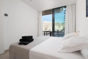 a bedroom with a bed and a large window at Mirador Blue K Cala Sant Vicenc in Cala de Sant Vicent