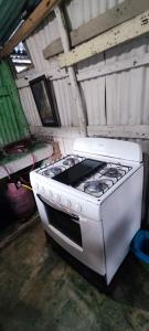 a stove top oven sitting inside of a building at La Loma Camping in Higuey