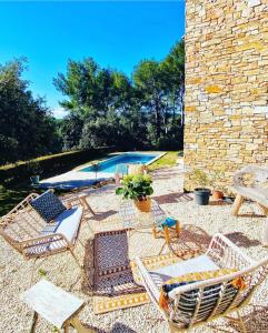 un patio con sillas, una mesa y una piscina en La grange des amoureux piscine jacuzzi et massages, en Le Beausset