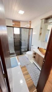 a bathroom with a shower and a toilet and a sink at La Casa de Gramado in Gramado