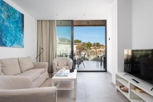 a living room with a couch and a tv at Mirador Blue K Cala Sant Vicenc in Cala de Sant Vicent