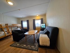 a living room with a couch and a table and a bunk bed at Lofotr Overnatting in Bøstad