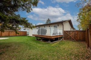 a house with a deck and a fence at Prairie South Charmer in Grande Prairie
