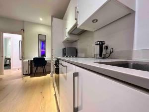 a kitchen with a sink and a counter top at Mayfair Stylish central London Modern Suite in London +15 photos