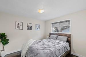 a bedroom with a bed and a window at Prairie South Charmer in Grande Prairie