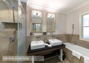 La salle de bains est pourvue de 2 lavabos, d'une douche et d'une baignoire. dans l'établissement Lenkerhof gourmet spa resort - Relais & Châteaux, à Lenk im Simmental