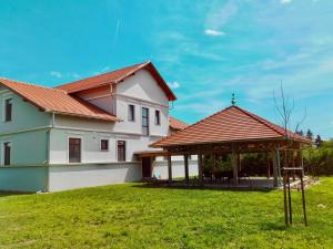 una casa con cenador en un patio en Kammerer Vendégház, en Kastélyosdombó