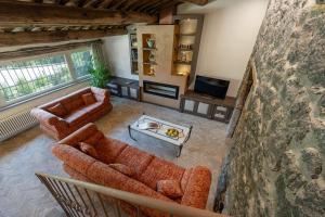 a living room with two couches and a tv at Villa Dorotea - Homelike Villas in Porano