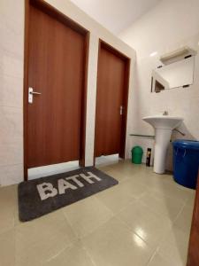a bathroom with a door and a sink and a rug at Timba chic-villa 1 in Cotonou