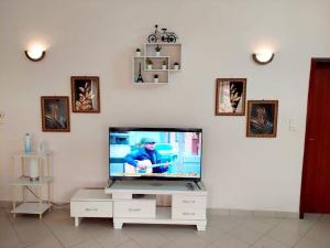 a living room with a television on a white wall at Timba chic-villa 1 in Cotonou