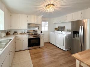  La cuisine est équipée de placards blancs et d'un réfrigérateur. dans l'établissement Mile High Organic Cottage, à Arvada