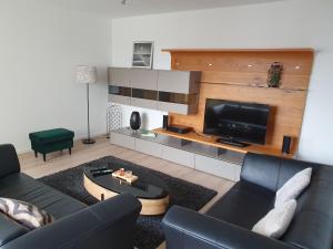 een woonkamer met een bank en een flatscreen-tv bij über den Dächern von Wolfsburg in Wolfsburg