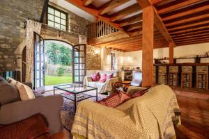 a living room with a couch and a table at The Coach House - Avec piscine partagée in Osserain-Rivareyte
