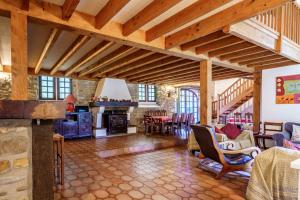 a large living room with a stone fireplace and wooden ceilings at The Coach House - Avec piscine partagée in Osserain-Rivareyte