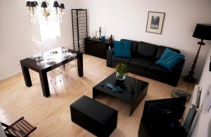 a living room with a black couch and a table at Triplex with Garage - Praça das Flores in Lisbon