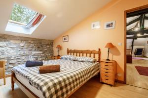 a bedroom with a bed and a stone wall at The Coach House - Avec piscine partagée in Osserain-Rivareyte