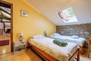 a bedroom with two beds and a window at The Coach House - Avec piscine partagée in Osserain-Rivareyte