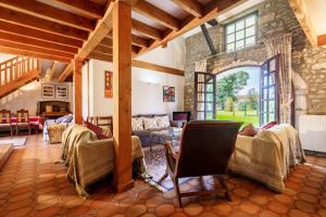 a large living room with a stone wall at The Coach House - Avec piscine partagée in Osserain-Rivareyte