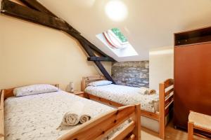 a bedroom with two twin beds and a window at The Coach House - Avec piscine partagée in Osserain-Rivareyte