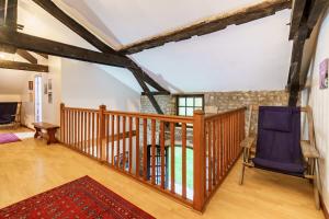 a wooden staircase with a blue chair in a living room at The Coach House - Avec piscine partagée in Osserain-Rivareyte