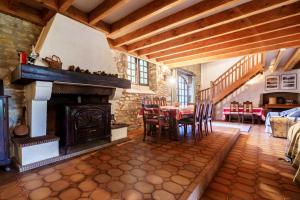 a living room with a fireplace and a table and chairs at The Coach House - Avec piscine partagée in Osserain-Rivareyte