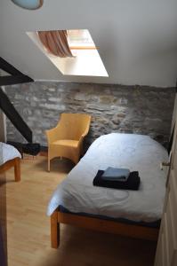 a bedroom with a bed and a yellow chair at The Coach House - Avec piscine partagée in Osserain-Rivareyte