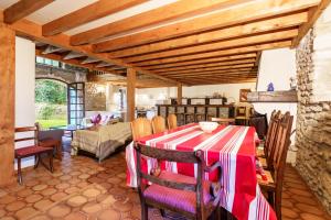 a living room with a table with a red and white table cloth at The Coach House - Avec piscine partagée in Osserain-Rivareyte +17 photos