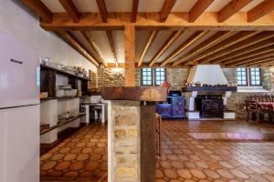 a kitchen with a refrigerator and a stove at The Coach House - Avec piscine partagée in Osserain-Rivareyte